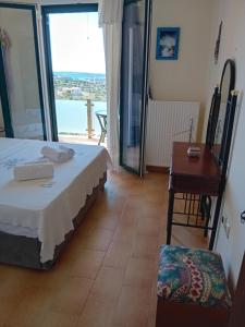 a bedroom with a bed and a desk and a window at Rikas in Porto Heli