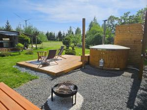 a wooden deck with a hot tub and two chairs at Ranczo u Jarka in Jeżyce