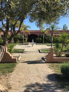 a park with benches and trees and a building at Domaine la Colomine in Canet-en-Roussillon