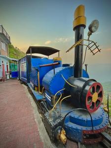 Un train bleu est assis sur les rails dans l'établissement Paradise Point Hotel & Restro, à Darjeeling