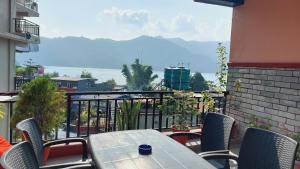 un tavolo e sedie su un balcone con vista di Golden Lake a Pokhara