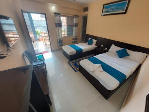 ein Hotelzimmer mit 2 Betten und einem Balkon in der Unterkunft Golden Lake in Pokhara