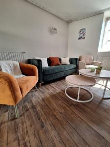 een woonkamer met een bank en een tafel bij Superbe maison dans le centre médiéval de Parthenay in Parthenay