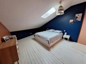 a bedroom with a blue wall and a bed at Superbe maison dans le centre médiéval de Parthenay in Parthenay