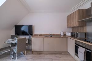 uma cozinha com uma mesa e uma televisão em Peterhead Stay - SJA Stays - Modern 2 Bed Apartment em Peterhead