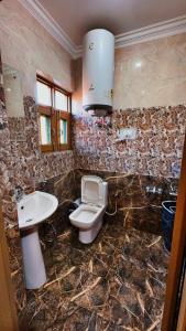 a bathroom with a toilet and a sink at Hotel Inabat Residency in Srinagar