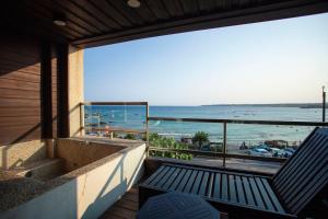 南灣的住宿－蝴蝶旅店，阳台设有长凳,享有海滩美景。