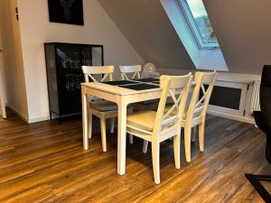 a dining room table with four chairs and a table at Ferienwohnung im Resi Gesundheitszentrum in Freudenberg