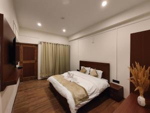 a bedroom with a large bed and a television at Zanu Residency in Leh