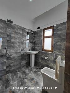 a bathroom with a toilet and a sink at Zanu Residency in Leh