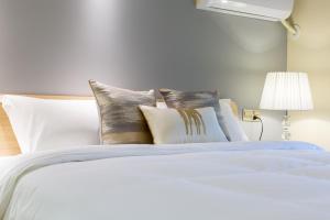a bed with white sheets and pillows on it at Serveyou International Apartment - Free Airport Pickup Service & Free Pazhou Complex Shuttle Bus & Free Sanyuan Li Xiaobei Baiyun Wholesale Market shuttle bus in Guangzhou