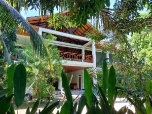 um edifício com uma varanda no meio das árvores em Hôtel La Belle Etoile em Labuan Bajo