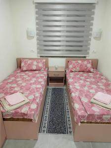 a room with two beds and a table at Apartmani-Sobe Manić in Soko Banja