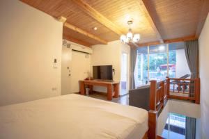 a bedroom with a bed and a tv and a window at Far Falla Hotel in Nanwan