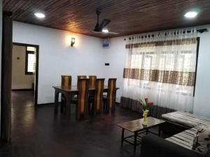 a dining room with a table and chairs and a couch at Villa Freedom in Ahangama