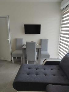 a living room with a table and a tv on the wall at Apartmani-Sobe Manić in Soko Banja