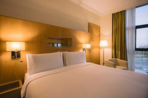 a hotel room with a large bed and a window at Holiday Inn Abu Dhabi, an IHG Hotel in Abu Dhabi