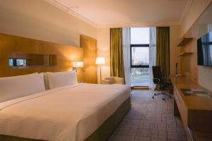 a hotel room with a large bed and a window at Holiday Inn Abu Dhabi by IHG in Abu Dhabi