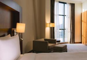 a hotel room with a bed and a chair and a window at Holiday Inn Abu Dhabi by IHG in Abu Dhabi