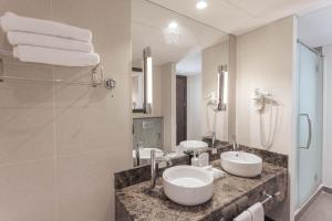 a bathroom with two sinks and a mirror at Holiday Inn Abu Dhabi by IHG in Abu Dhabi