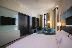 阿布達比的住宿－阿布扎比假日酒店，酒店客房设有一张大床和一台电视。