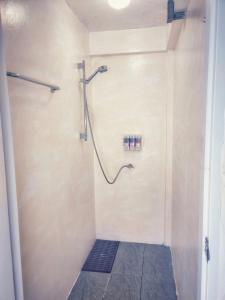 eine Dusche im Bad mit Fliesenboden in der Unterkunft HOLY SHEET Hostel in Bangkok