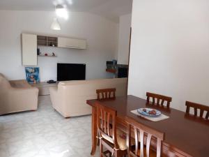 a living room with a table and chairs and a couch at La terrazza di Valeria in Scario