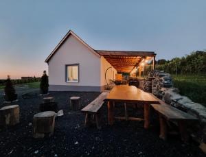a house with a table and benches in front of it at Somló Nordic in Somlószőlős