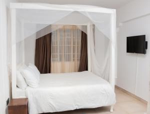 un letto bianco a baldacchino in una camera da letto di Sunnyside Inn a Blantyre