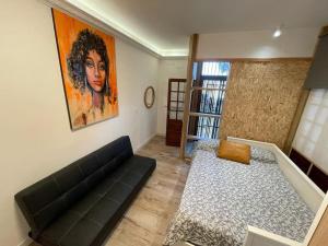 a living room with a black couch and a painting at Las Caletillas vacations, 20 meters from the beach in Santa Cruz de Tenerife