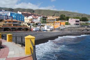 uma vista para uma praia com edifícios e o oceano em Las Caletillas vacations, 20 meters from the beach em Santa Cruz de Tenerife