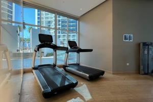 a gym with a treadmill and a large window at Business Bay centrally located Cozy Studio in Dubai