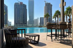 a patio with tables and chairs and a view of a city at Business Bay centrally located Cozy Studio in Dubai