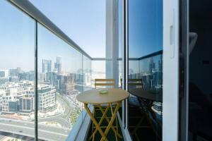 Business Bay centrally located Cozy Studio في دبي: بلكونه مع طاوله واطلاله على مدينه