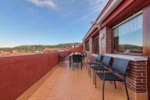 a balcony with chairs and a table on a building at Ático con 2 terrazas, 25m2 cada una By urban hosts in Górliz-Elexalde