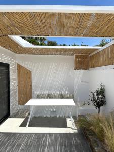 a white building with a wooden ceiling and a bench at AESIS in Krokos