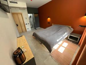 1 dormitorio con 1 cama en una habitación con paredes de color naranja en Florian en Kamianets-Podilskyi