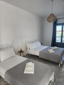 1 dormitorio con 2 camas y ventana en Eleios Hotel Serifos, en Livadion