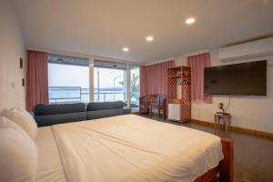 a bedroom with a bed and a couch and a flat screen tv at Far Falla Hotel in Nanwan