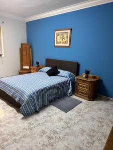 a blue bedroom with a bed and a night stand at Marsaskala Sea Side Retreat in Marsaskala