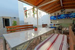 a patio with tables and benches in a building at Vila Kristian in Ksamil