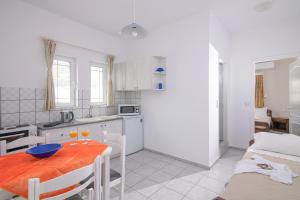 eine Küche und ein Esszimmer mit einem Tisch und Stühlen in der Unterkunft Litsa Mare Apartments in Agia Pelagia