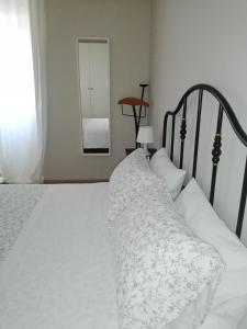 um quarto com uma cama branca e um espelho em Arina Home -Aeroporto Fontanarossa- em Catânia
