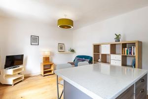 uma cozinha e sala de estar com uma mesa e uma televisão em A Tranquil One-Bedroom Flat near Brockwell Park em Londres