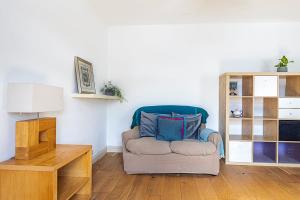 uma sala de estar com uma cadeira e uma mesa em A Tranquil One-Bedroom Flat near Brockwell Park em Londres