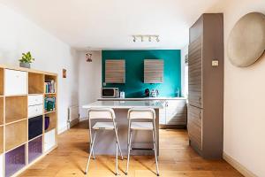 uma cozinha com uma mesa e dois bancos em A Tranquil One-Bedroom Flat near Brockwell Park em Londres