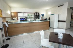 un ristorante con bar, tavolo e frigorifero di HOTEL DON CAMILLO a Brescello