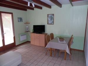 a living room with a table and a tv at Le Viognier - Gîte - Lot (vallée de la Dordogne) in Saint-Michel-de-Bannières