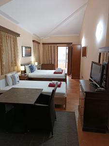a hotel room with two beds and a television at Villa Beatrix Budva in Budva