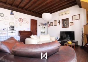 a living room with a leather couch and a tv at MyStay - A Casa do Visconde in Mértola +28 photos